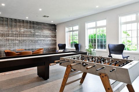 a game room with a foosball table and chairs