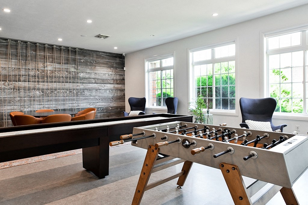 a game room with a foosball table and chairs