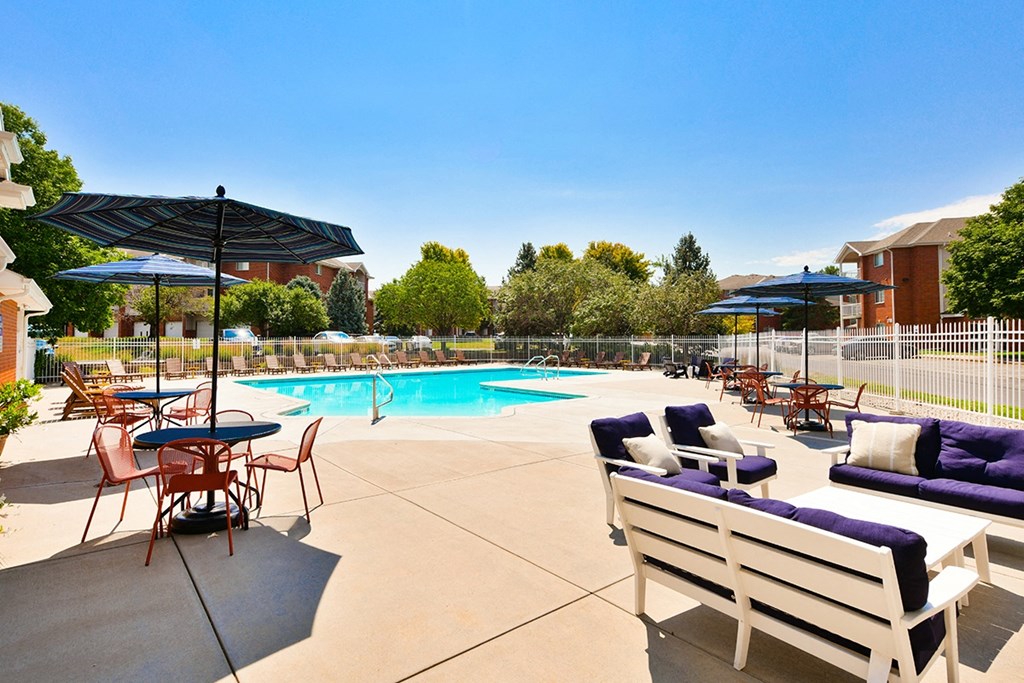 our apartments have a swimming pool and patio with chairs and umbrellas