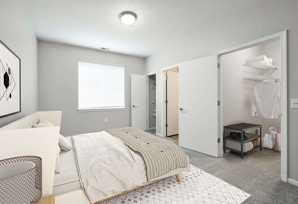 Spacious bedroom with a large window and plenty of space in the walk in closet.