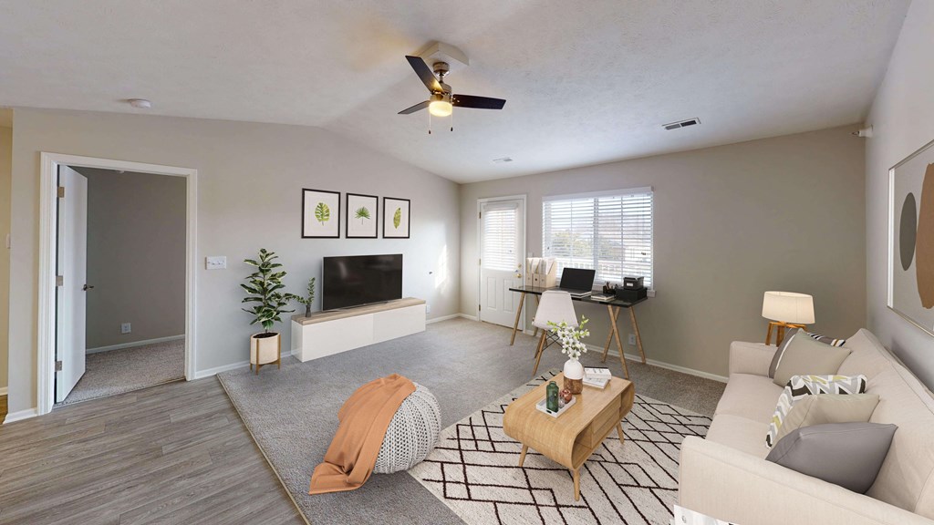 Spacious and airy living area in a top unit with vaulted ceilings and a large window.
