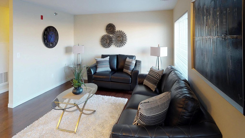 a living room with leather furniture and a white wall