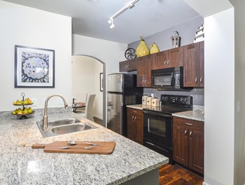 Spacious kitchen featuring stainless steel appliances, granite countertops, and white cabinetry. - Photo Gallery 3