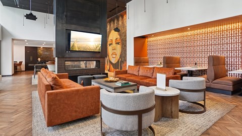A living room with a fireplace and a painting of a woman on the wall.