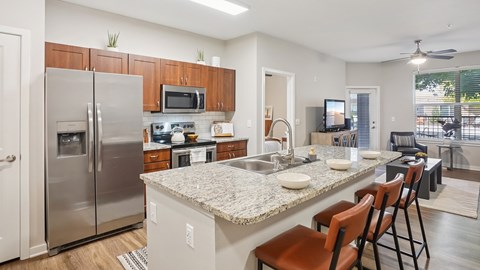 A kitchen with a granite countertop and stainless steel appliances.