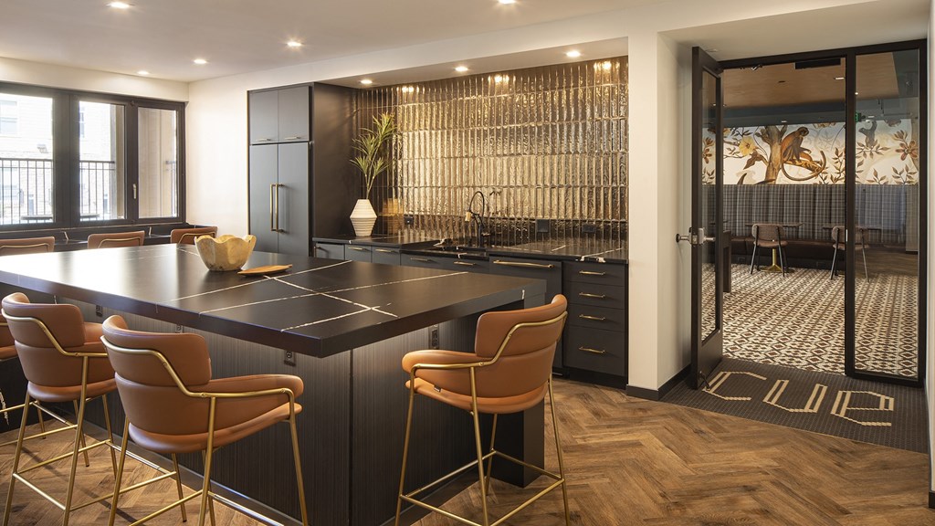 a kitchen with a large island and a bar with chairs