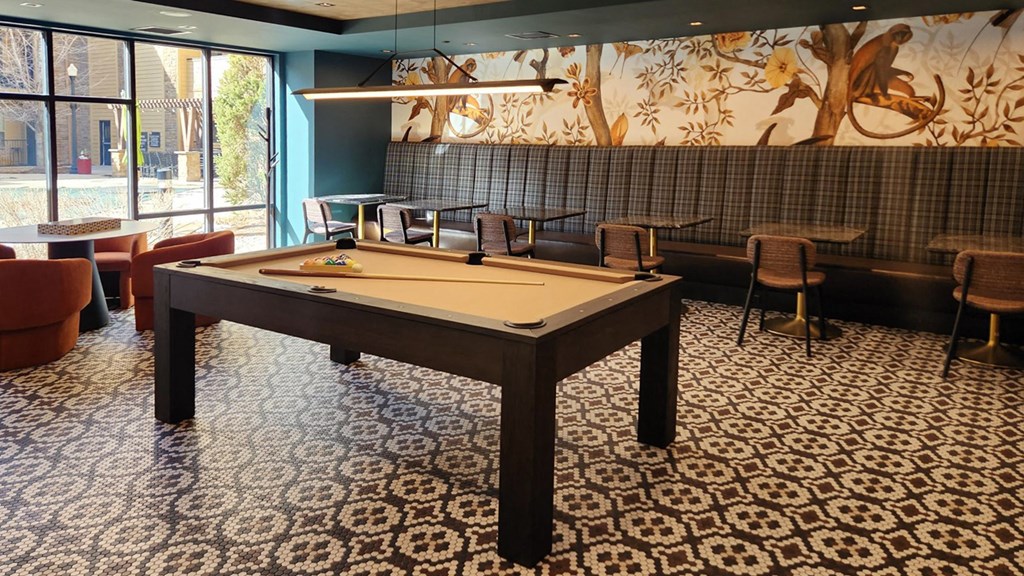 a pool table in a room with tables and chairs