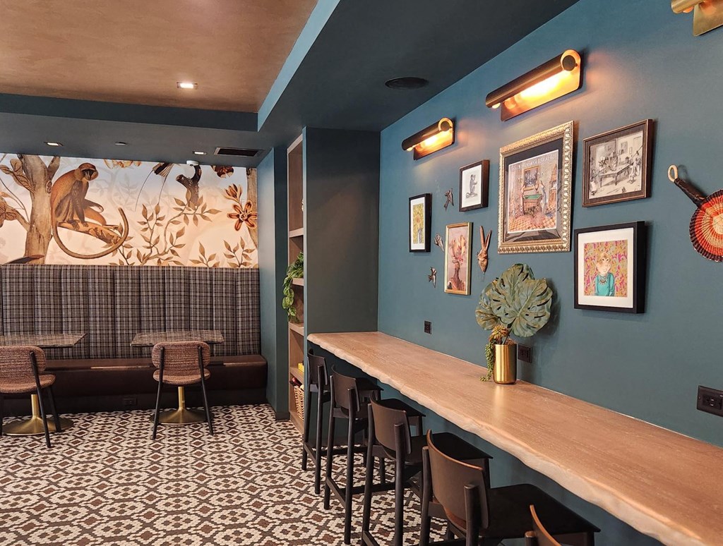 a dining room with a long wooden bar and a mural on the wall