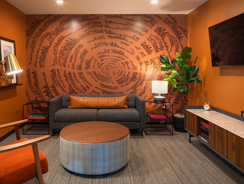 a living room with orange walls and a gray couch