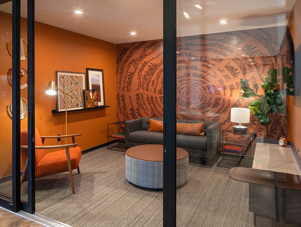 a living room with orange walls and a large mural on the wall