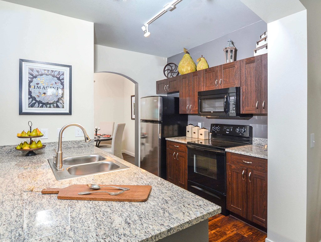 Spacious kitchen featuring stainless steel appliances, granite countertops, and white cabinetry.