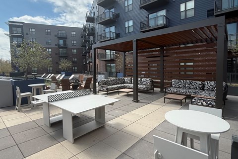 A patio with a table and chairs is surrounded by apartment buildings.