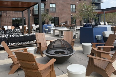 A patio with chairs and a fire pit.