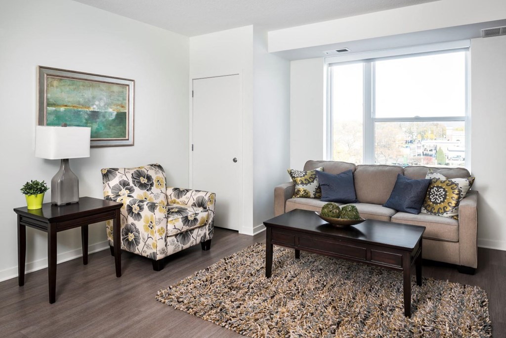 Furnished Living room with wood panel flooring, couch, arm chair and coffee table