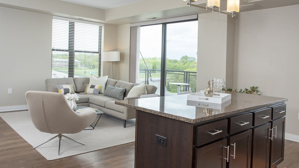 a living room with a couch and a table with a kitchen