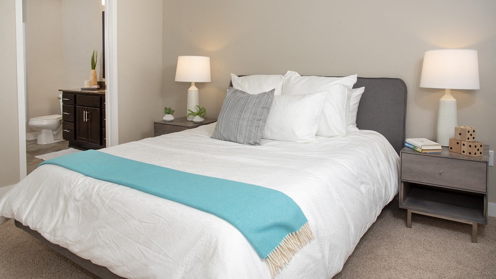 a bedroom with a large white bed and a blue blanket