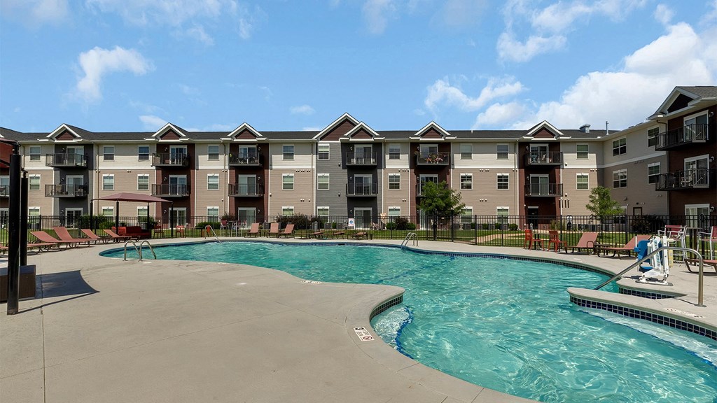 a swimming pool with an apartment building in the background