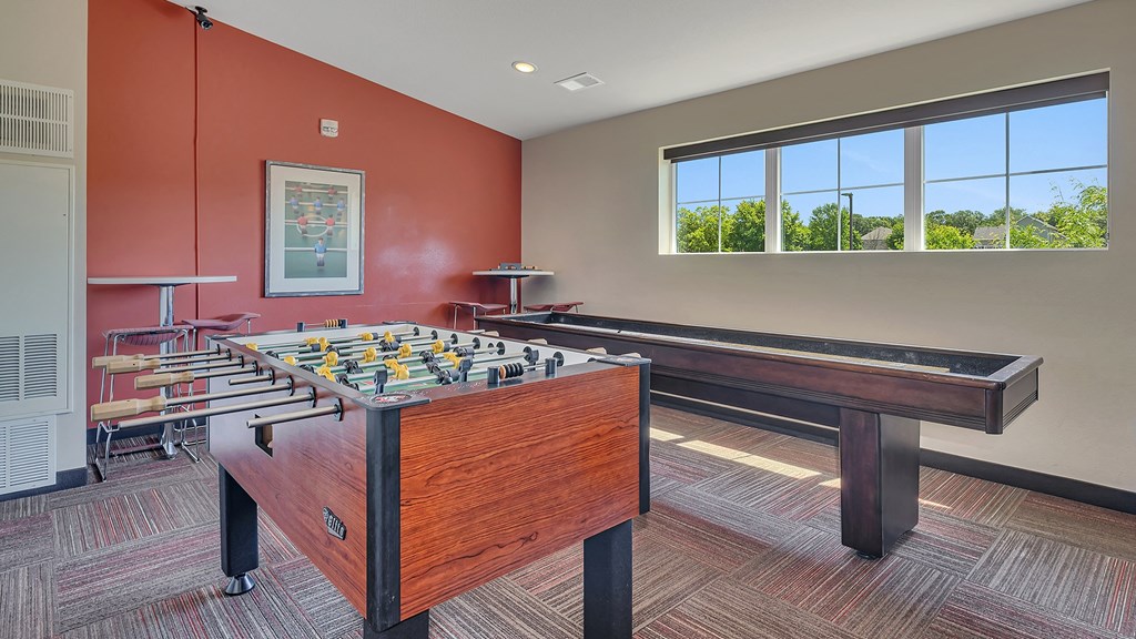 a games room with a foosball table and a bar