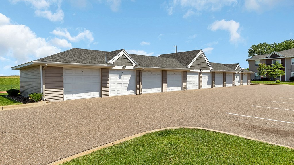 a house with white garage doors and a driveway in front of it