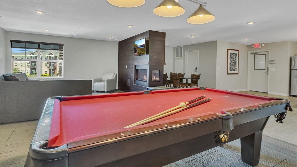 a red pool table in a living room with a fireplace