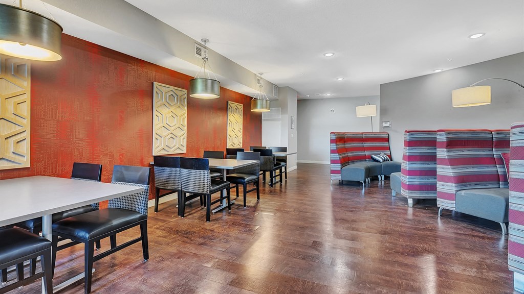 a dining room with tables and chairs in front of a red wall