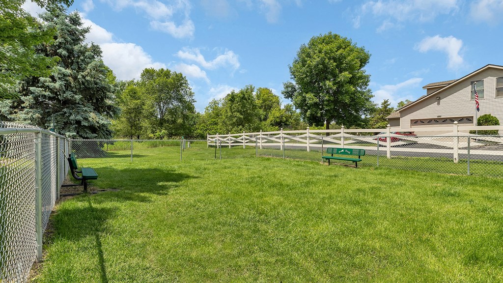 a fenced in backyard with a white fence and benches