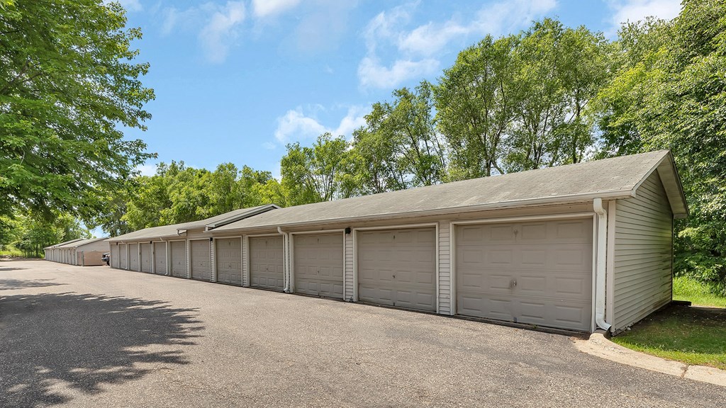 a row of garages in a parking lot with trees
