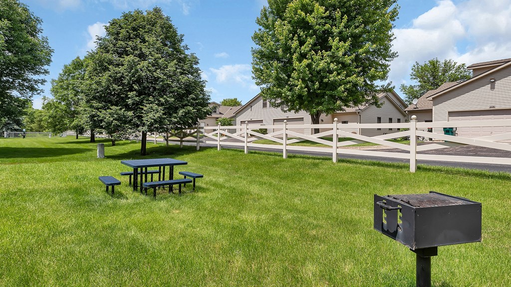 our yard has a picnic table and a grill and a fence