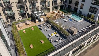 A rooftop patio with a pool and lounge chairs.