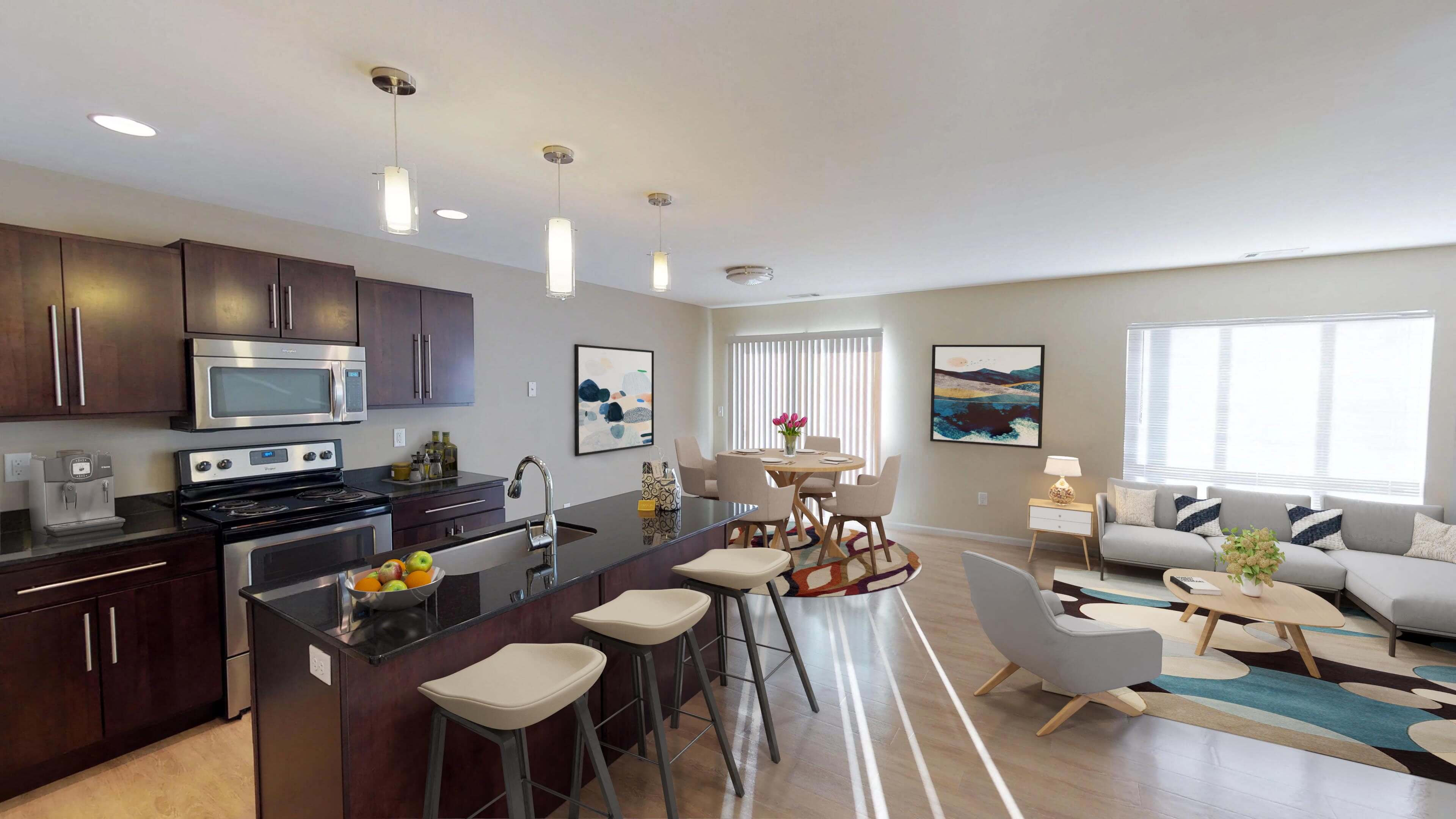 Open kitchen and living area with a large window and door to balcony or patio. Kitchen has dark wood cabinetry and large island for entertaining.