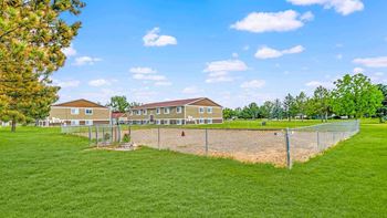 a fenced in area with houses in the background