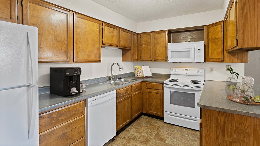 a kitchen with white appliances and wooden cabinets