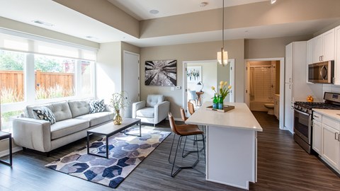 a living room with a kitchen and a couch and a table