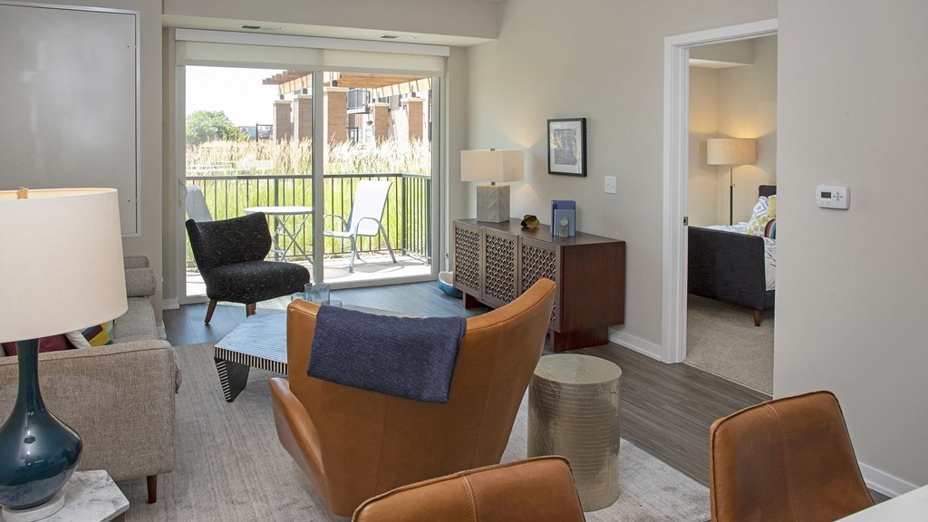 a living room with chairs and a table and a balcony