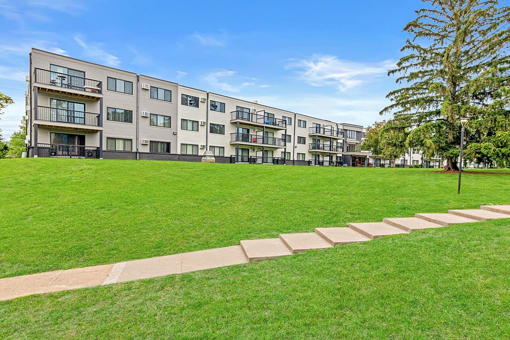A large grassy area in front of apartment buildings.