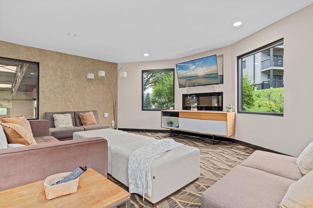 A living room with a couch, a coffee table, and a large window.