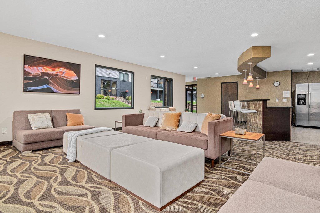 A living room with a grey sofa, a grey bed and a brown carpet.