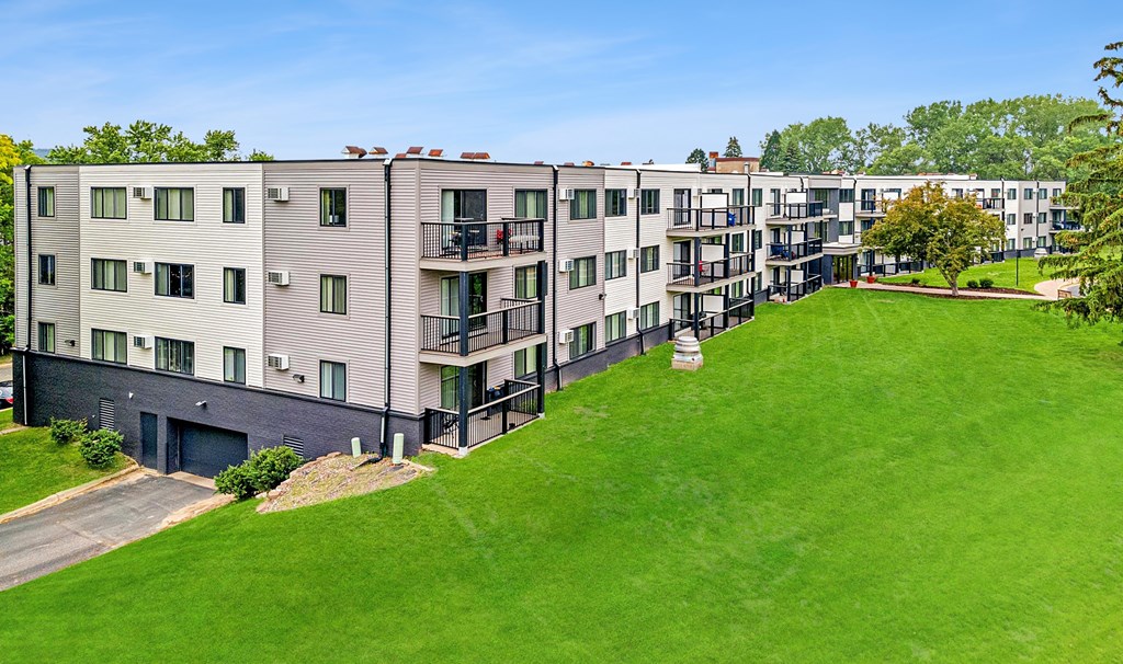 Apartment complex with green grassy area in front.