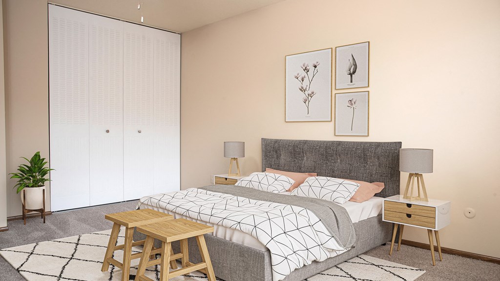 A bedroom with a bed, nightstands, and a plant.