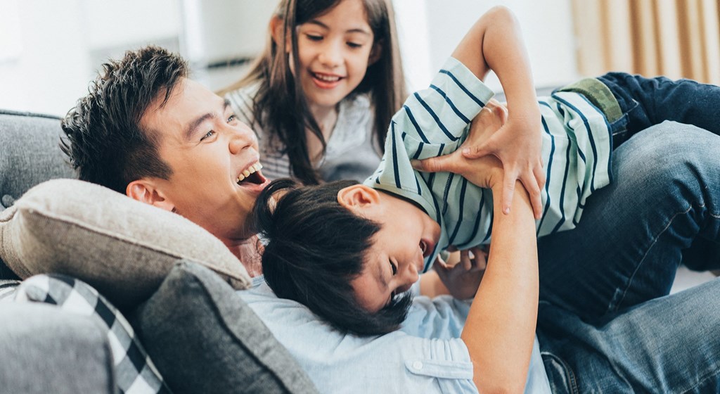 a man and a woman are sitting on a couch with a young boy and girl