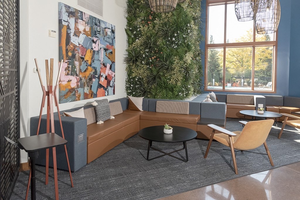 a living room with couches and chairs and a wall with a plant