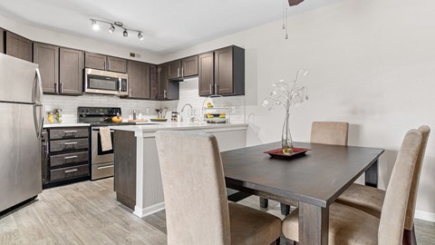 a kitchen and dining room with a table and chairs