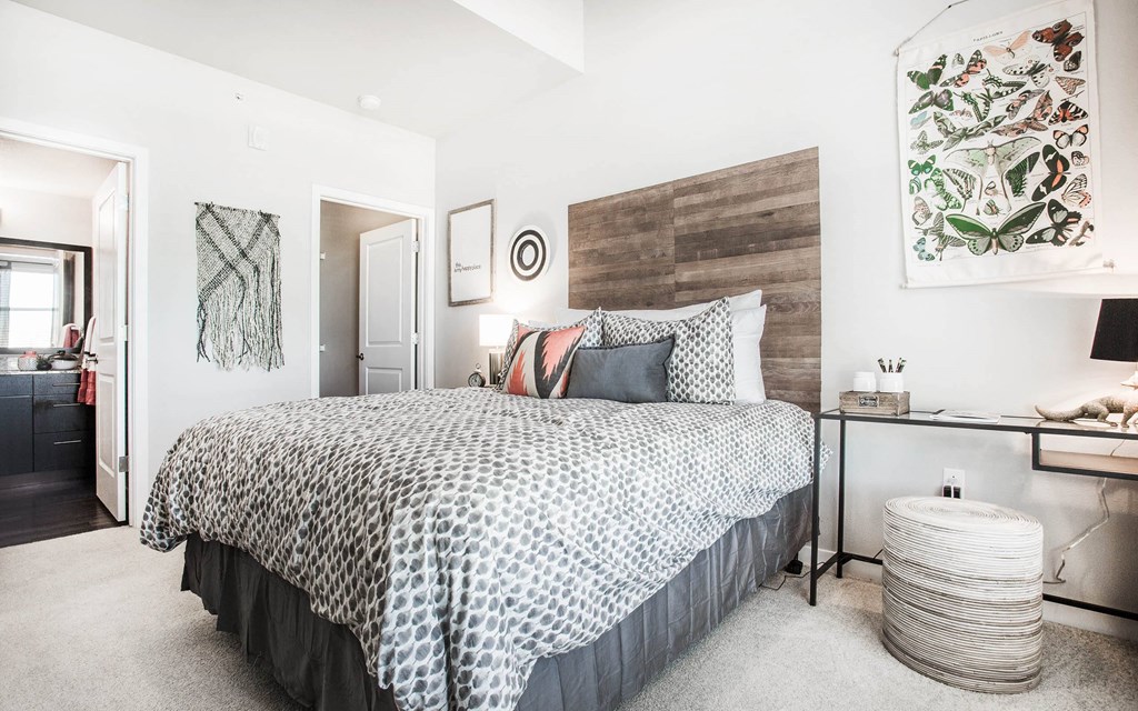 Furnished bedroom with king bed, wall art and attached private bathroom