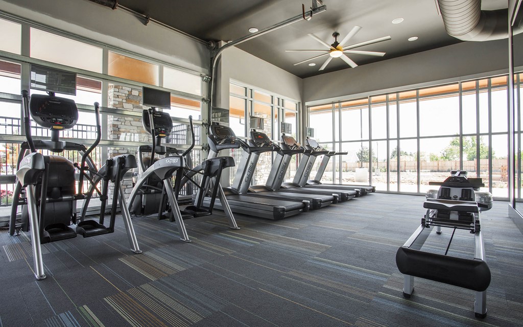 Fitness Center with four treadmills, three ellipticals and row machine on tactical carpeted floor