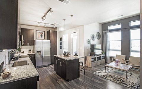 a kitchen and living room with a refrigerator and a sink