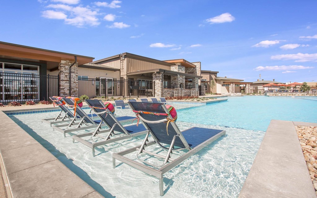 Outdoor pool with sun chairs in shallow end