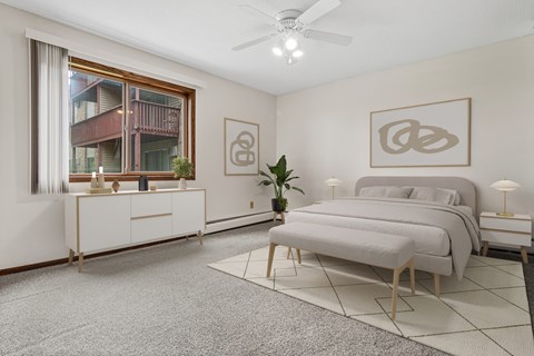 A bedroom with a large bed, a dresser, and a ceiling fan.