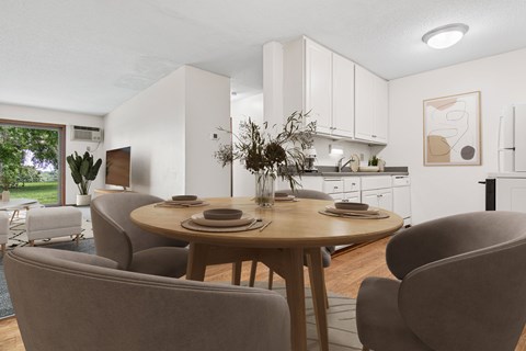 A modern dining room with a round table and grey chairs.