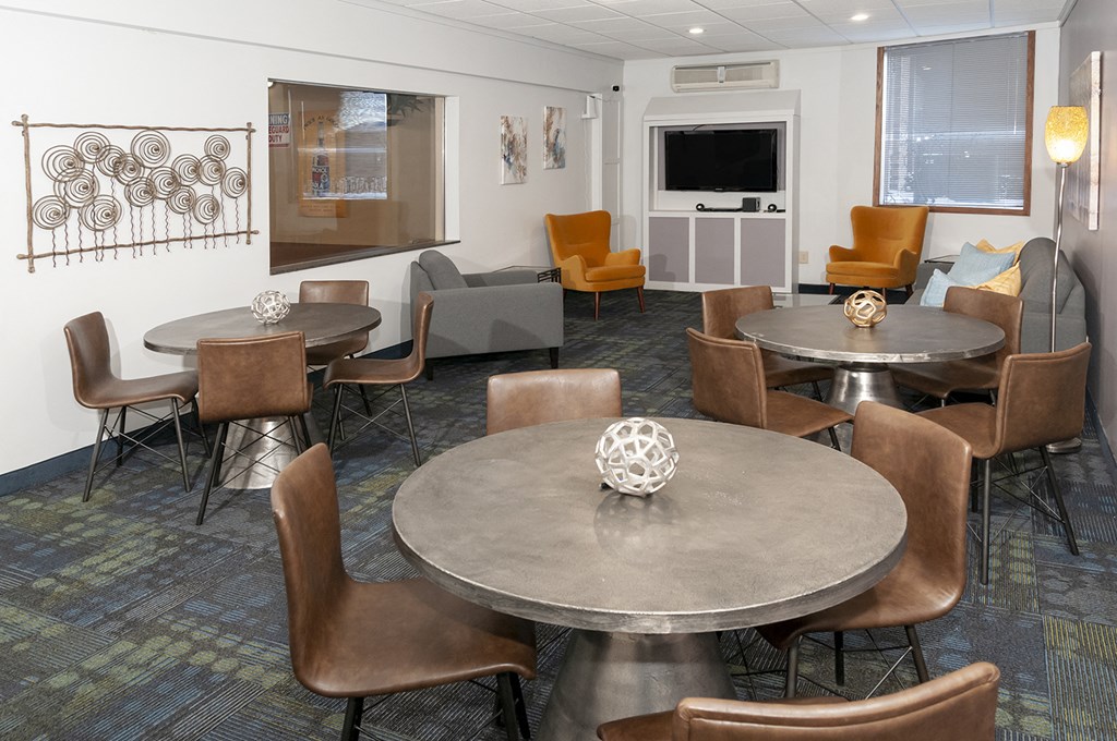 a conference room with tables and chairs and a television