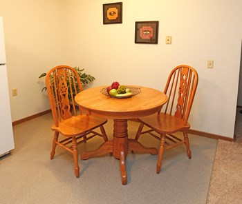 Small circular dining room table with two wooden chairs, adjacent to kitchen - Photo Gallery 5